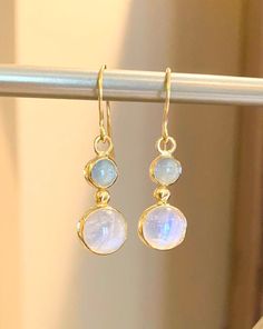 "Moonstone (10mm) and Aquamarine (6.5) set in 22 karat gold.  Stunning pair of drop earrings with the soft color of light blue aquamarine and the billowy moon-like sheen of the moonstone cradled in 22 karat yellow gold. The earring dangle 1.5\" from the earlobe." Elegant Moonstone Drop Earrings, Formal Round Moonstone Earrings, Moonstone Round Yellow Gold Earrings, Moonstone Yellow Gold Round Earrings, Blue Moonstone Round Earrings, Yellow Gold Moonstone Dangle Earrings, Round Moonstone Yellow Gold Earrings, Round Moonstone Cabochon Earrings, Yellow Gold Round Moonstone Earrings