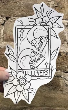 someone holding up a sticker that says it lovers on the side of a brick wall