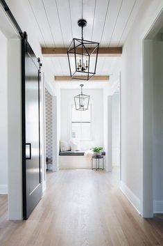 an empty hallway with wood floors and white walls