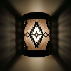 a light that is on the side of a wall in a dark room with lights coming from it