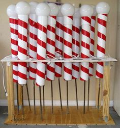 several red and white candy canes are stacked on top of each other in front of a wall