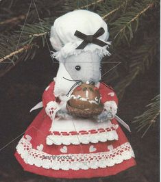 a white mouse in a red dress holding a piece of bread