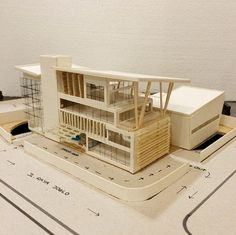 a model of a house on top of a table with construction plans in the foreground