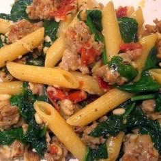 pasta with meat and spinach on a white plate