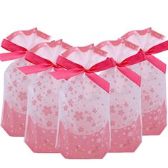 six pink gift bags with bows on them