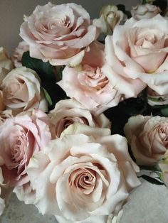 a bouquet of pink roses sitting on top of a table