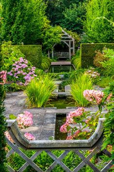 a garden with lots of plants and flowers in it's center, surrounded by greenery