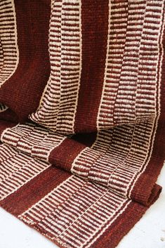 three brown and white striped rugs sitting on top of each other