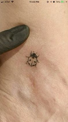 a ladybug tattoo on the side of a woman's right stomach is shown