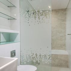 a bathroom with a glass shower door next to a white toilet