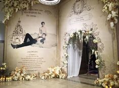 an open book with flowers and candles in front of it on the floor next to a chandelier