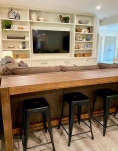 a living room filled with furniture and a flat screen tv mounted on a wall above it