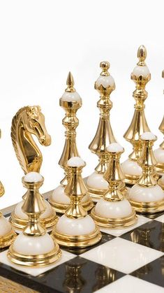 a gold and white chess set on a checkered board