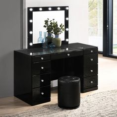 a black vanity with lights on it and a stool