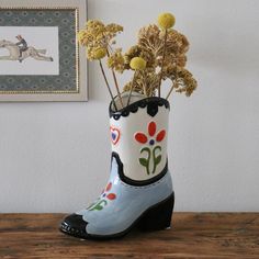 a boot with flowers in it sitting on a table