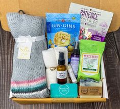 an open box with some items in it on top of a wooden table next to a pillow