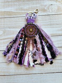 a keychain made out of feathers and beads on a wooden surface with a chain