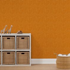 an empty room with yellow walls and wicker baskets on the floor next to it