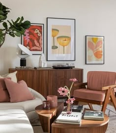 a living room filled with furniture and pictures on the wall above it's coffee table