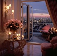 a living room filled with furniture next to a window covered in candles and flowers on top of a table