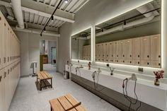 an empty locker room with benches and lights