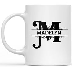 a white coffee mug with the letter m in black and white lettering, on a white background