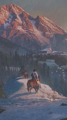 two people riding horses on top of a snow covered mountain