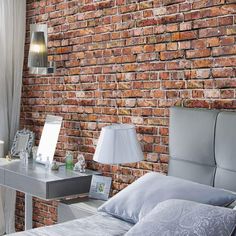 a bedroom with a brick wall behind the bed