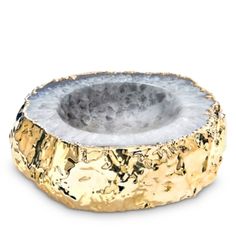 a gold and white stone bowl on a white background