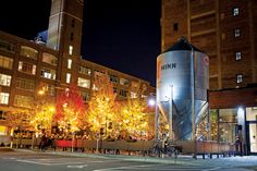 a large metal silo sitting in the middle of a street next to tall buildings