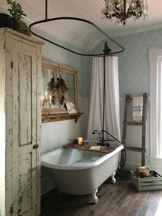 a bathroom with a claw foot tub and chandelier hanging from it's ceiling