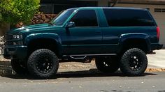 a green truck parked in front of a house