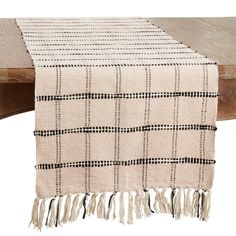 a wooden table with a white and black checkered table runner on top of it