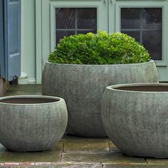 two large planters sitting on top of a wooden floor