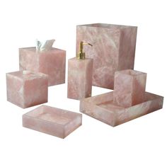 pink marble bathroom accessories including soap dispenser, toothbrush holder and tissue dispenser