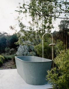 an outdoor bathtub in the middle of a garden