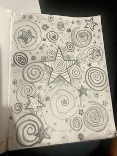 a drawing with spirals and stars in the middle, on top of a piece of paper