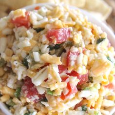 a white bowl filled with pasta salad next to crackers