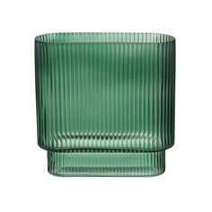 a green glass vase sitting on top of a white surface