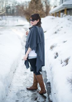 a woman standing in the snow wearing boots