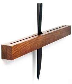 a wooden shelf with two knifes on it and a black handle hanging from the wall