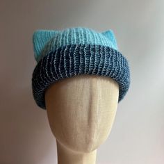 a mannequin head wearing a knitted hat with blue and white stripes on it