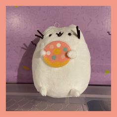 a stuffed animal that has a doughnut in it's mouth