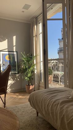 a bed sitting in a bedroom next to a window with an open door on top of it