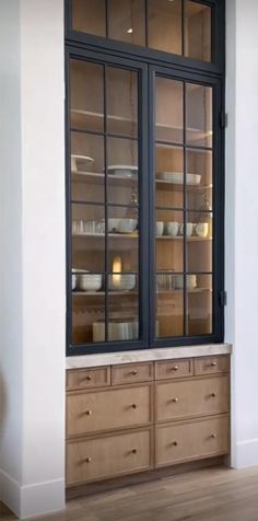 an empty glass fronted cabinet in the corner of a room