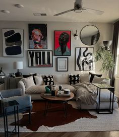 a living room filled with lots of furniture and pictures on the wall above it's coffee table