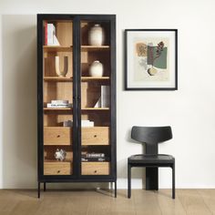 a black chair sitting in front of a wooden cabinet