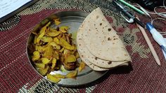 some food is sitting on a metal plate and next to a paper with writing utensils