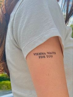 a woman with a tattoo on her arm that says, vienna waits for you in black ink