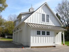 a large white barn with a black roof